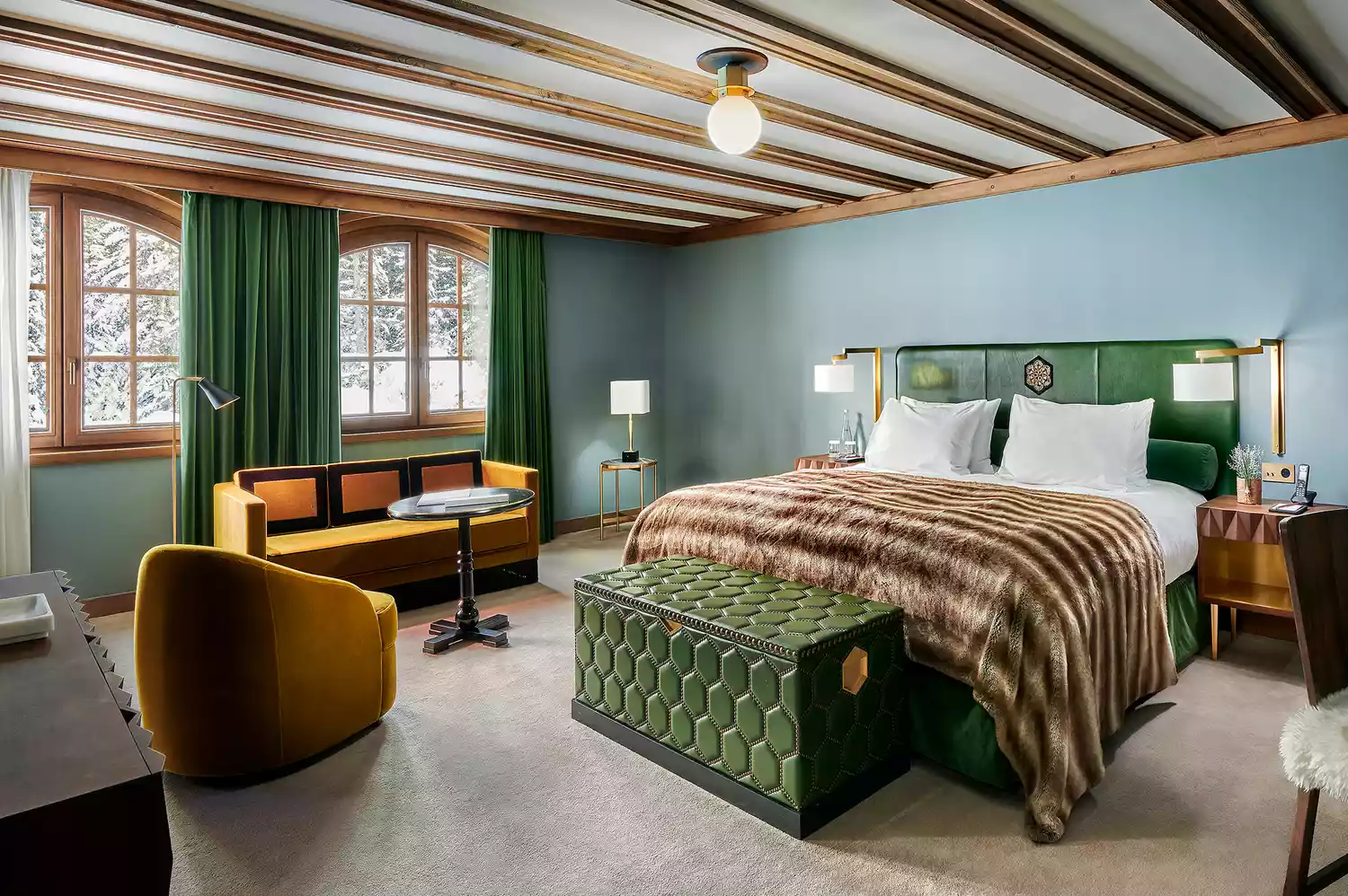 A luxurious and cozy hotel guest room with neutral tones and mountain-inspired decor.