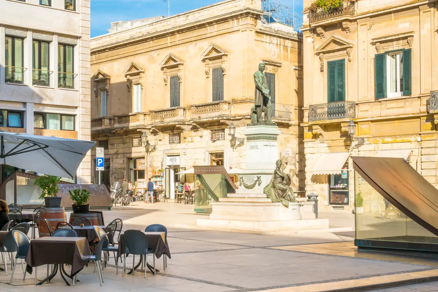 Charming outdoor cafe tables set in a sun-drenched historic plaza in Lecce.