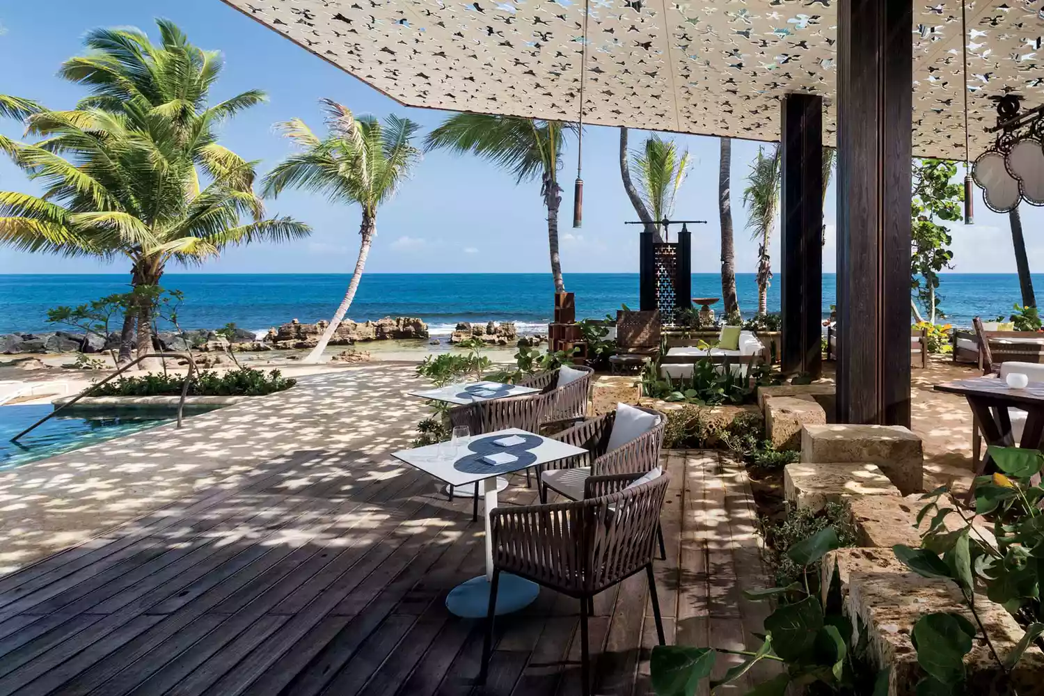 A private pool terrace at the Ritz-Carlton Reserve in Dorado overlooking a white sand beach.