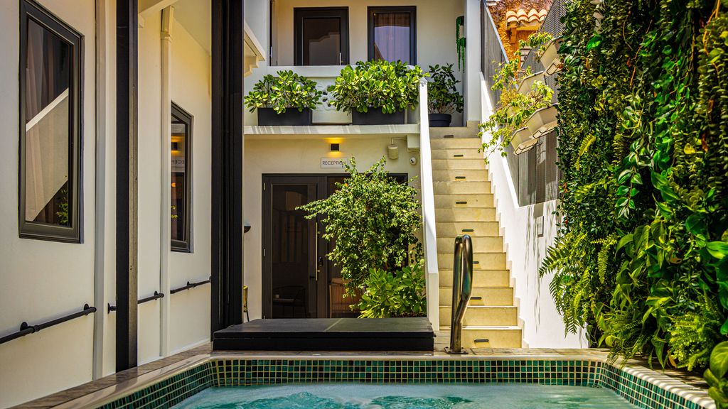 Interior courtyard and staircase of Patio Elba with potted plants and historic details.