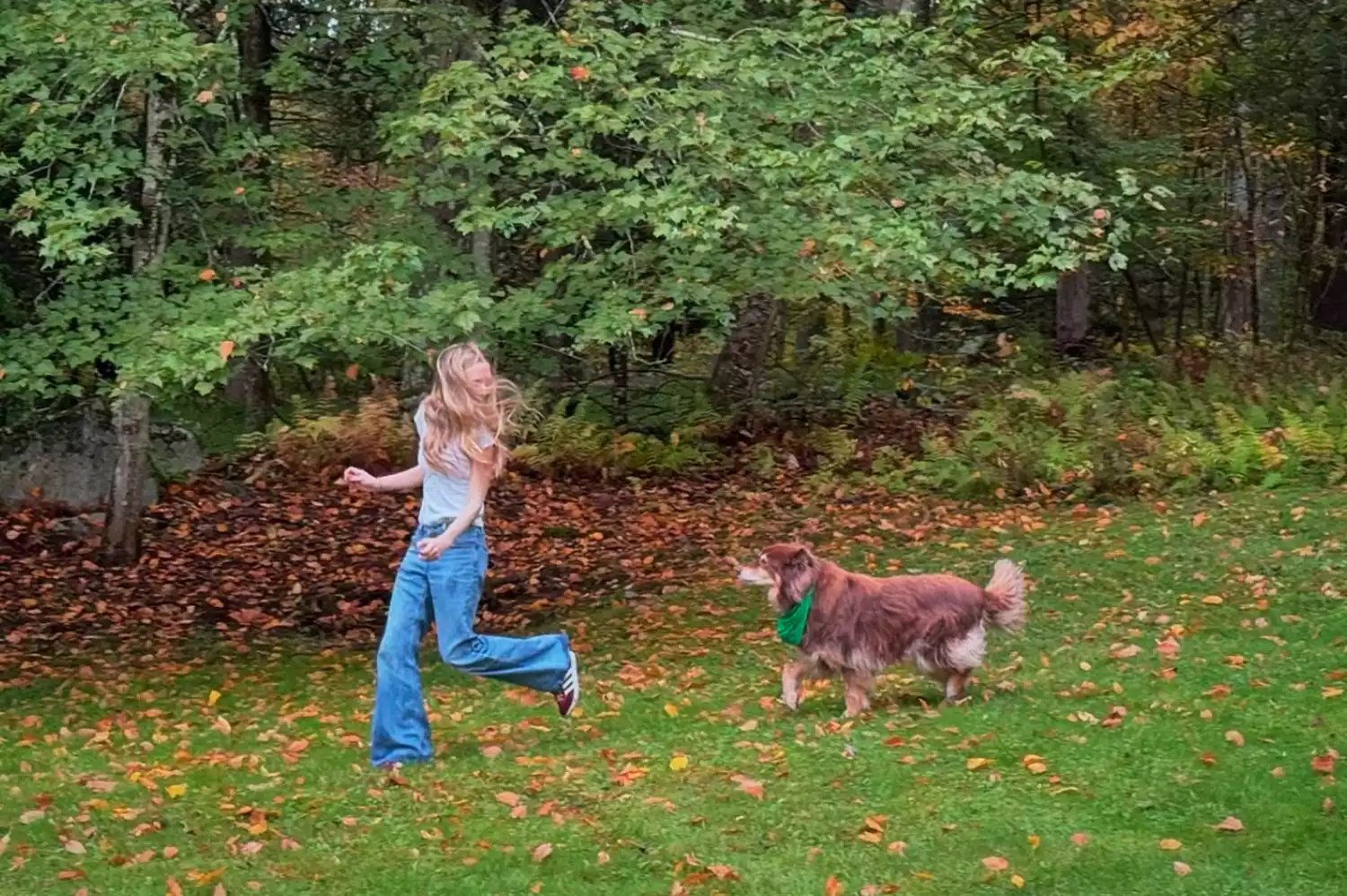 Amanda Seyfried running through a green meadow with her dog Finn in Upstate New York.
