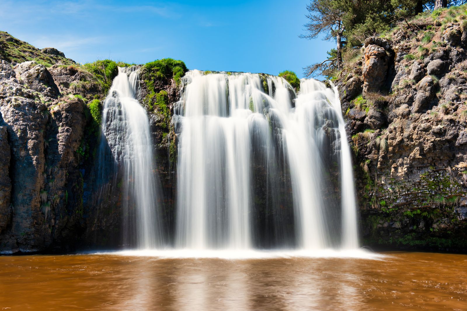 Natural waterfall and rocky landscape in the volcanic Auvergne region.