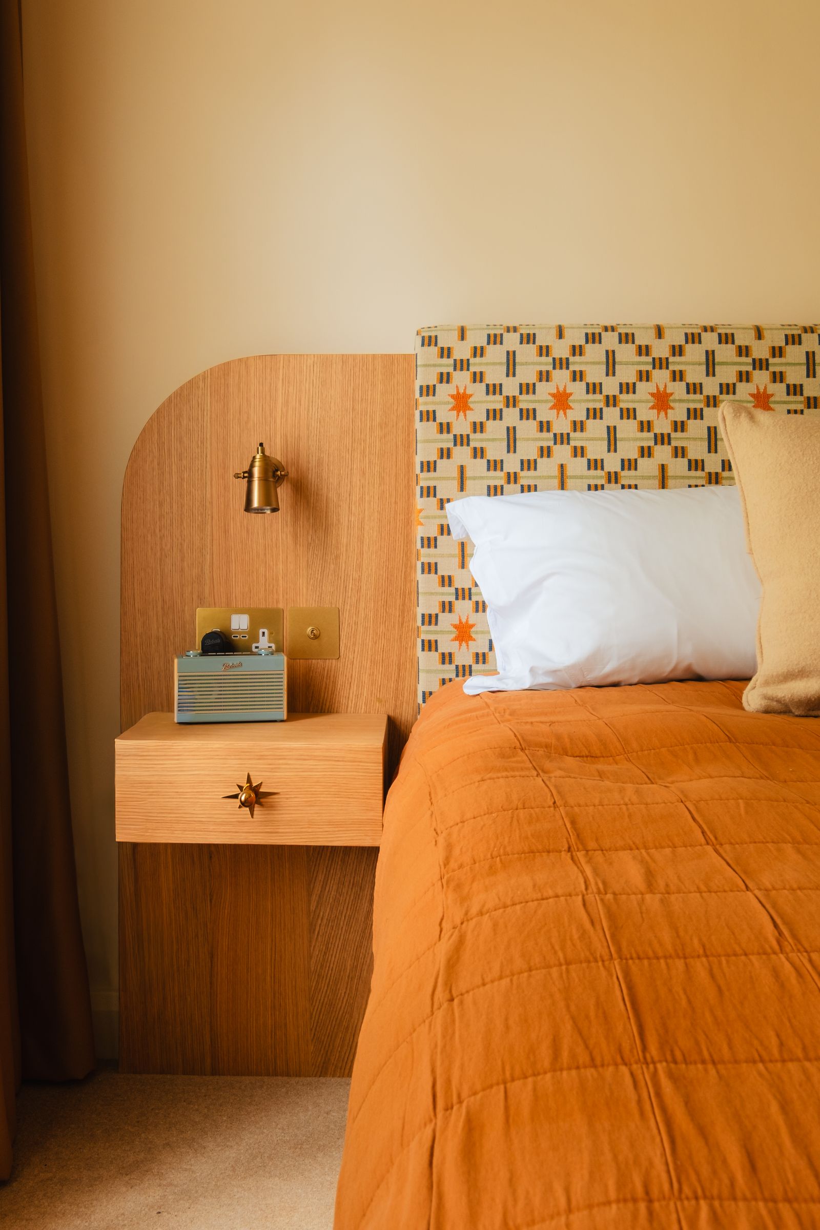 A minimalist guest bedroom featuring wood paneling, tactile fabrics, and a calm color palette.