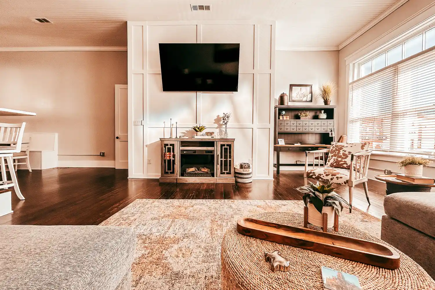 A cozy, well-lit living room inside a restored historic home in Waxahachie featuring a decorative fireplace.
