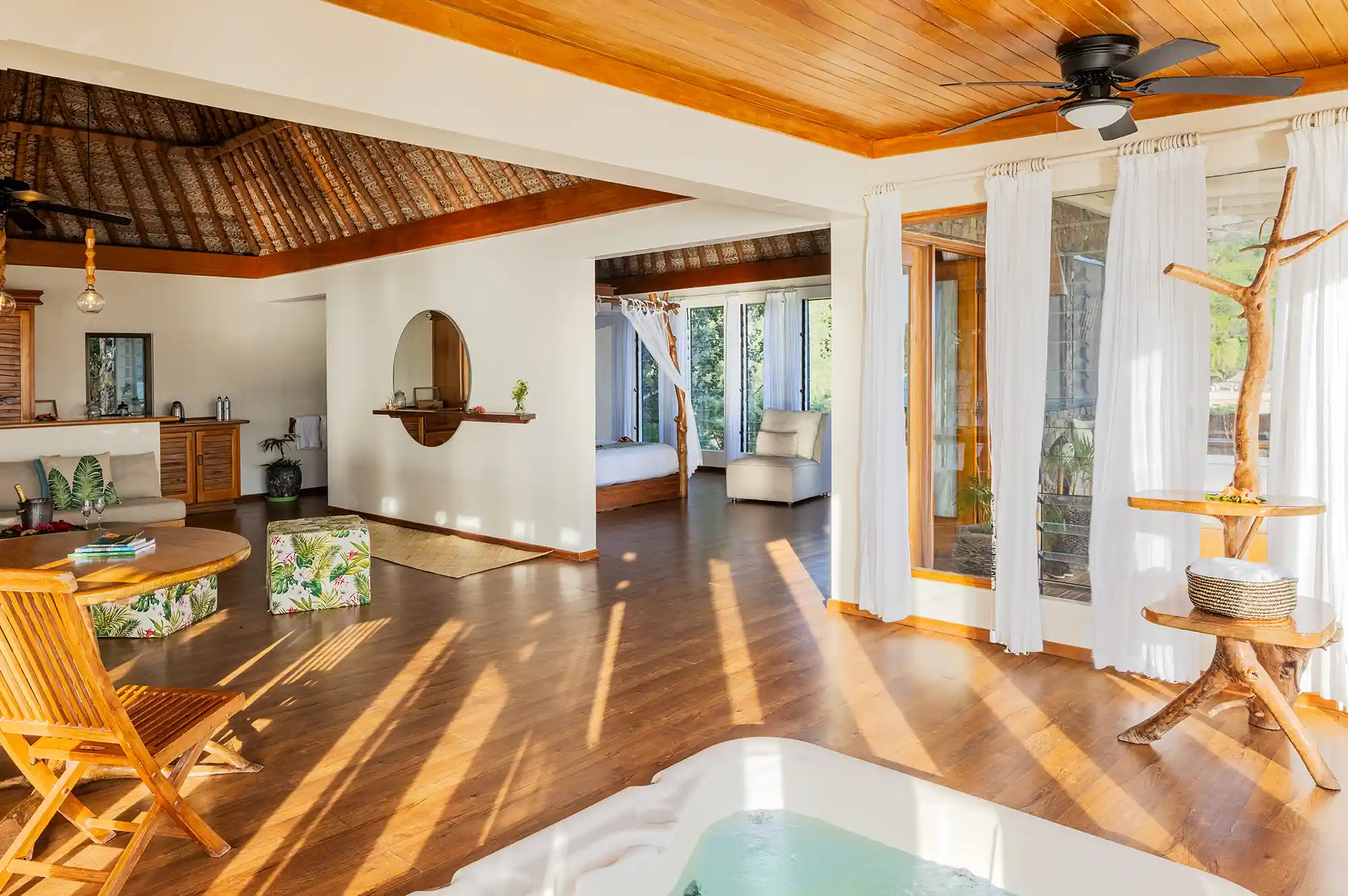 Interior of a traditional Fijian bure with high wooden ceilings and open-air layout.