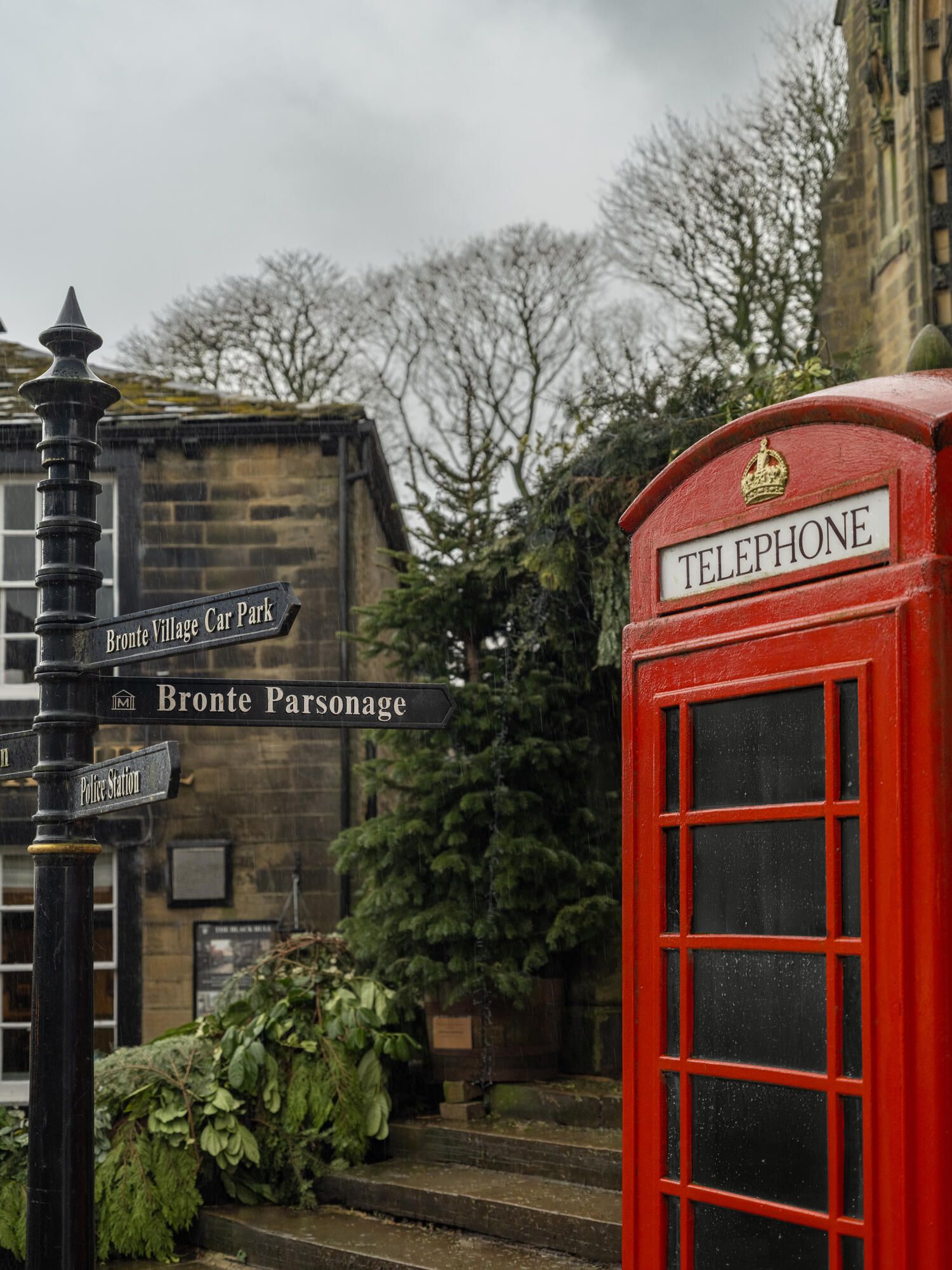 A classic British red telephone booth and road signage in a rural West Yorkshire setting.