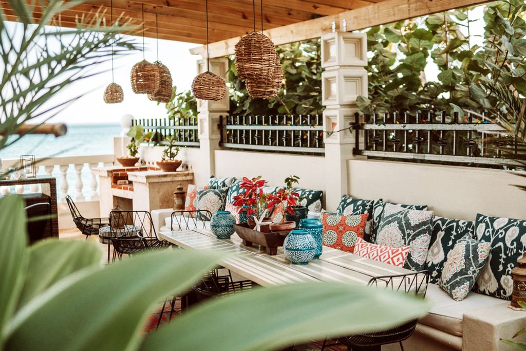 Oceanfront view of Tres Sirenas Beach Inn with palm trees and beach access.