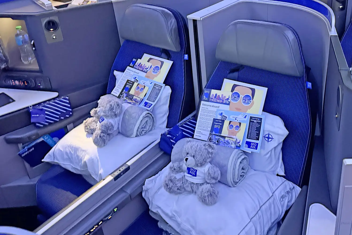 United Polaris business class cabin seats with pillows, blankets, and amenities.