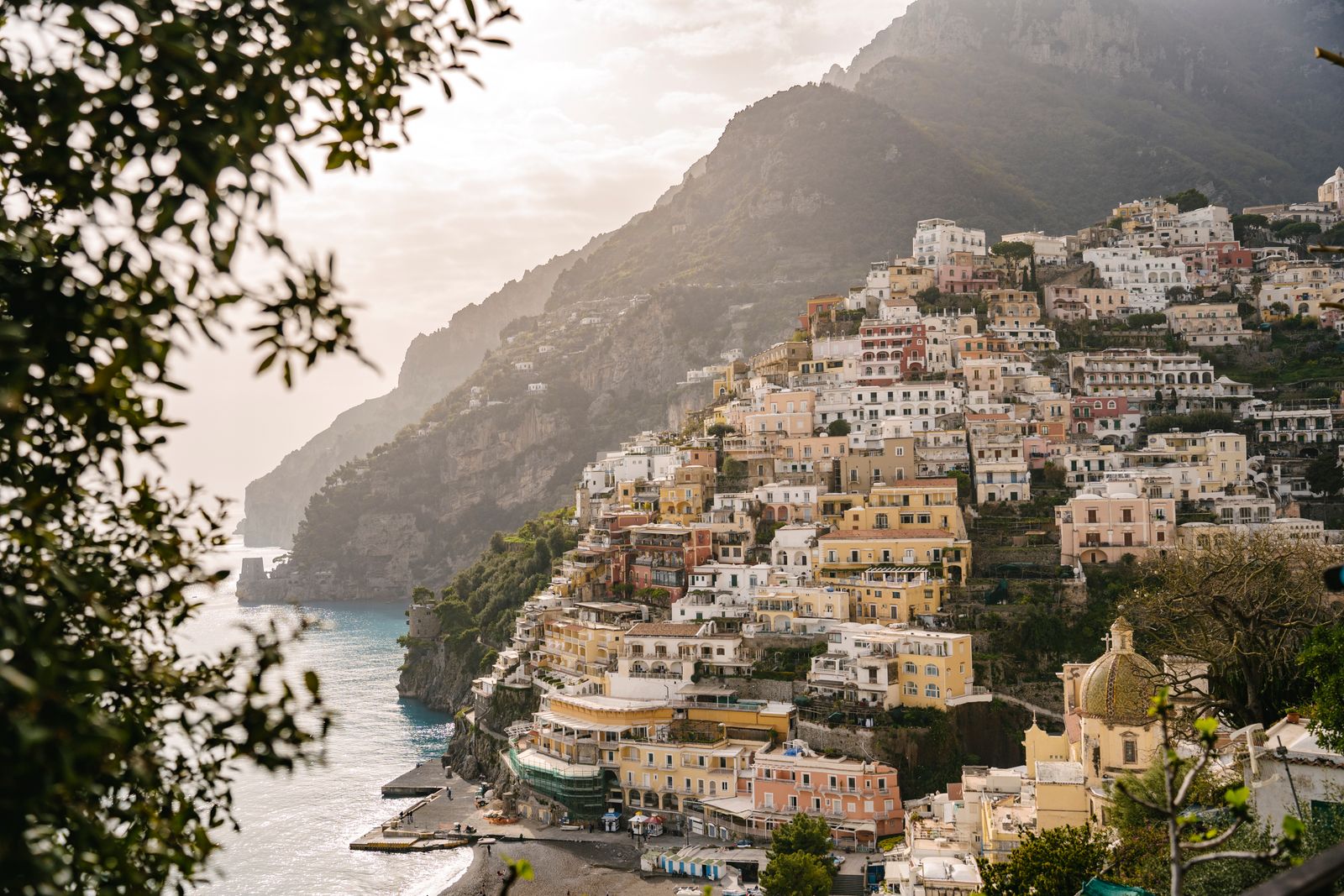 A vibrant cityscape of colorful houses stacked on a hillside overlooking the sea.