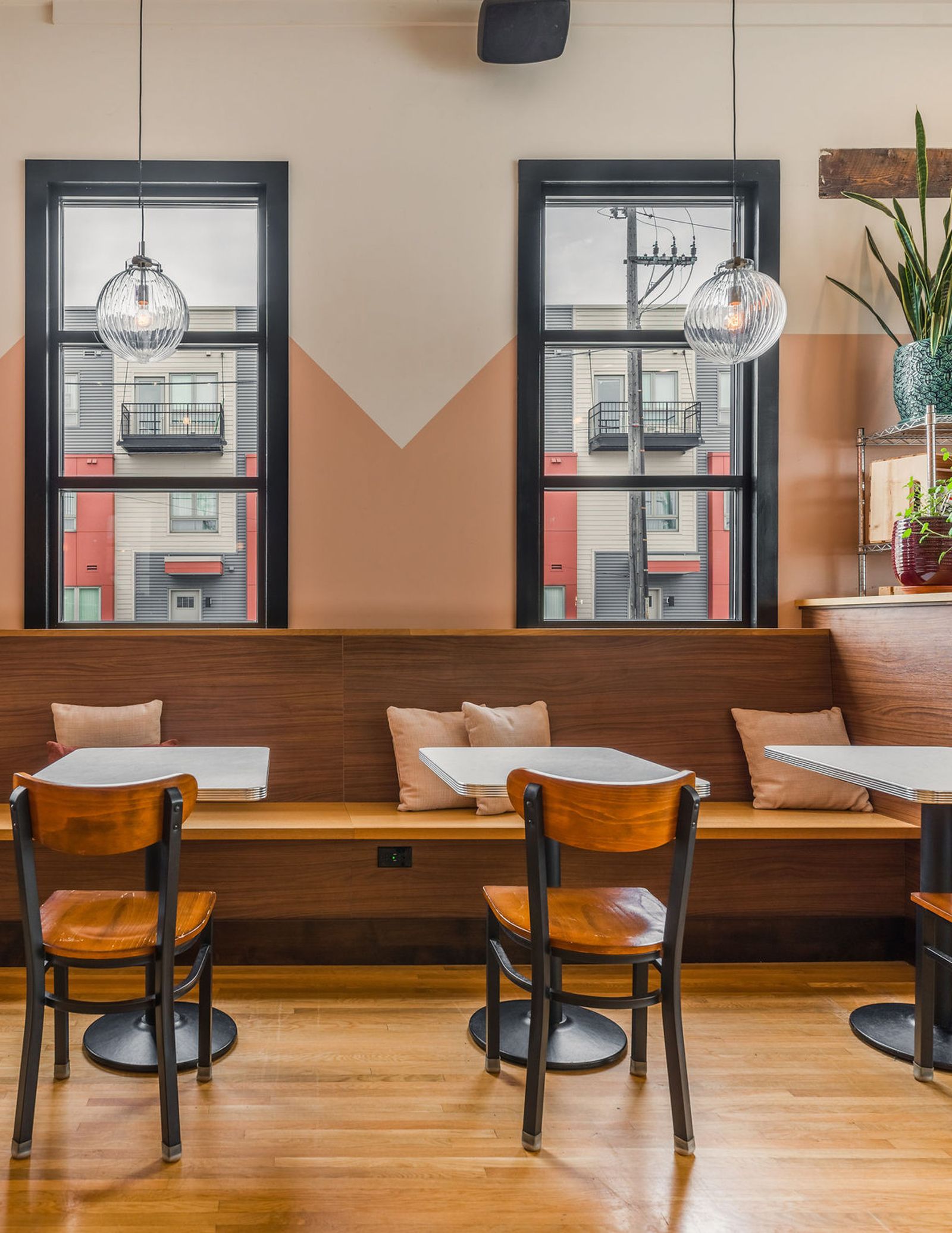 Interior view of a modern restaurant featuring minimalist wooden furniture and architectural design.