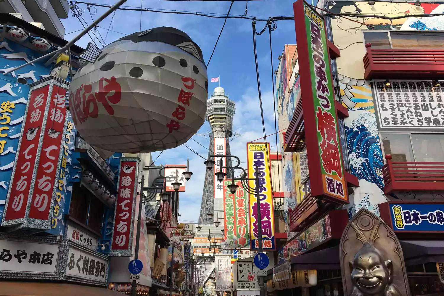 The neon-lit streets and Tsutenkaku tower in the Shinsekai district of Osaka, Japan.