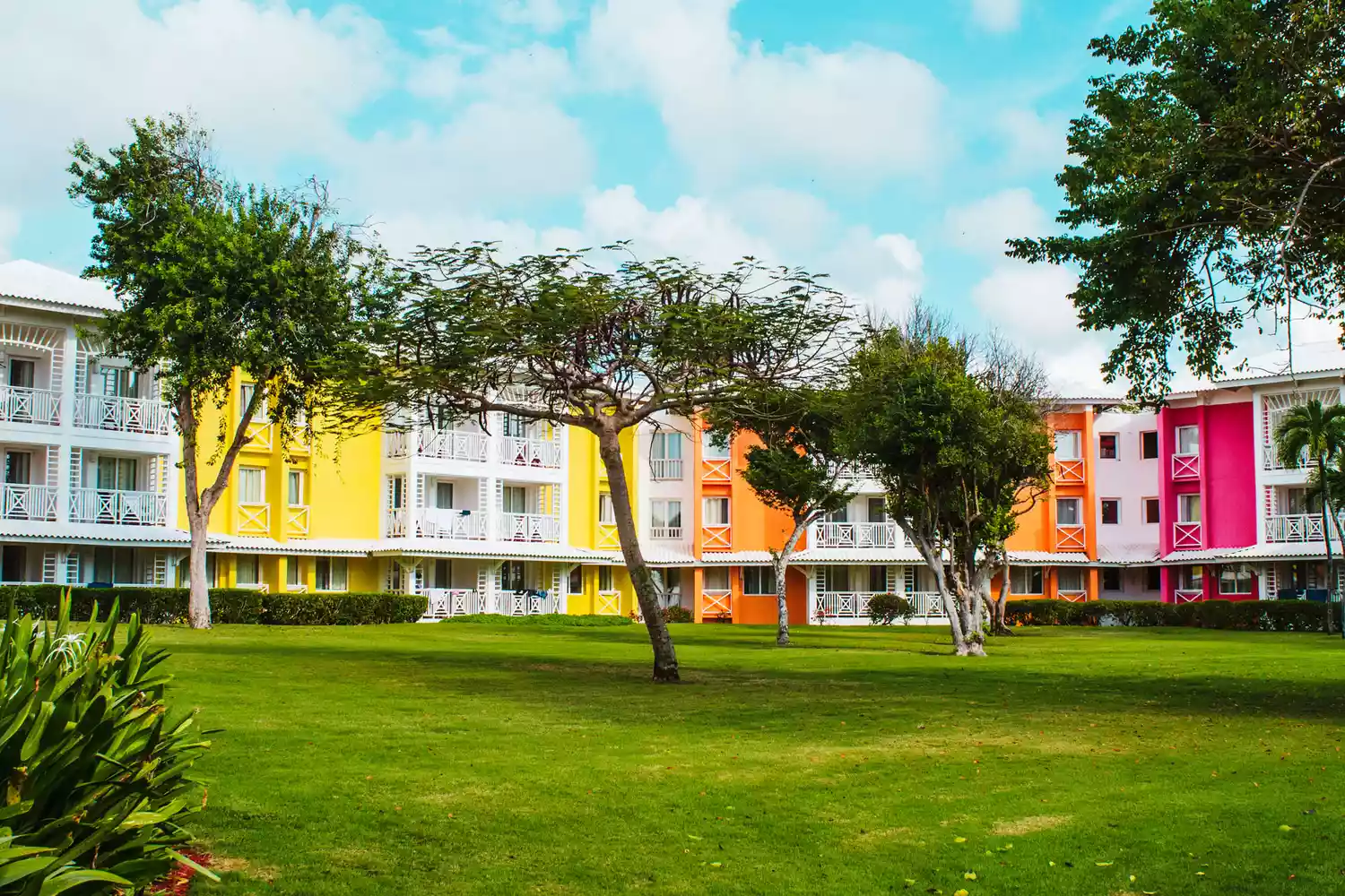 Brightly colored tropical resort buildings at Club Med Punta Cana under a clear blue sky.