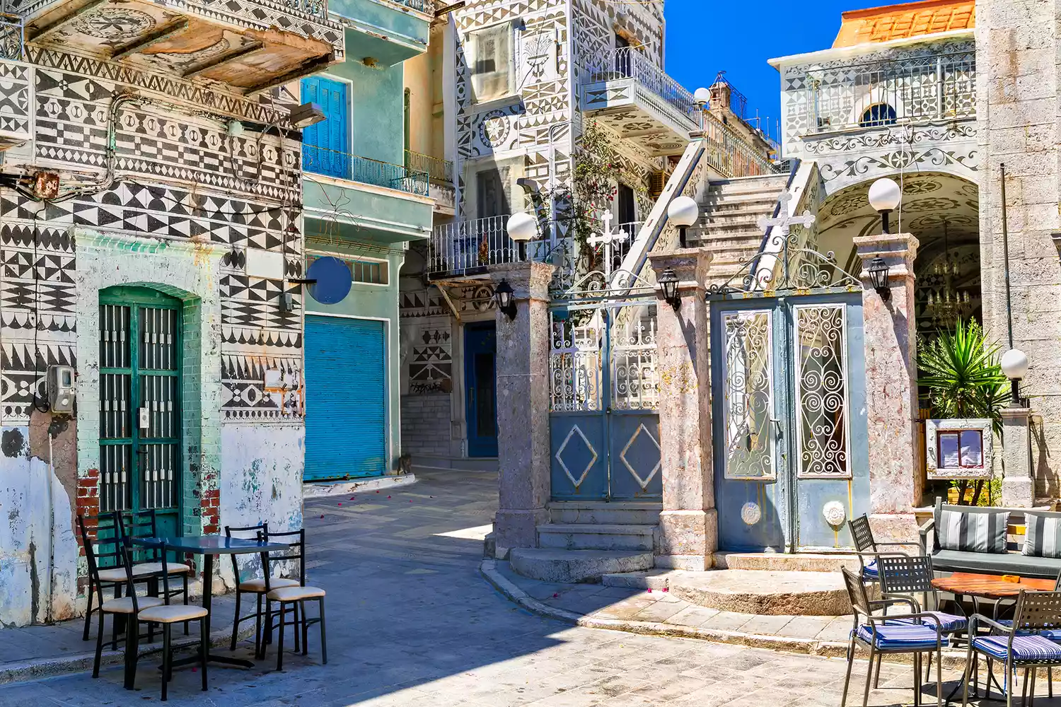 Traditional houses in Pyrgi, Greece, adorned with black and white geometric 'Xysta' engravings.