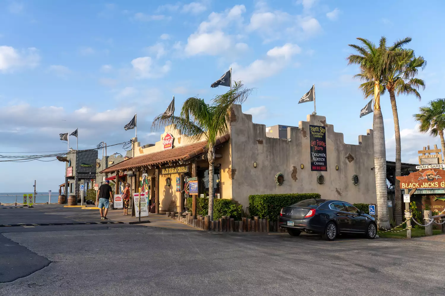 A colorful tourist shop and boat tour office with pirate flags located along the waterfront in Port Isabel near Port Aransas.