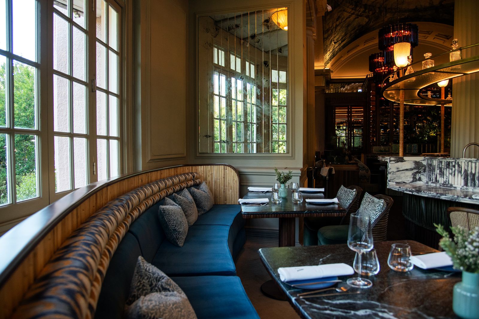 A sophisticated lounge area with plush furniture and plants in a boutique hotel setting.