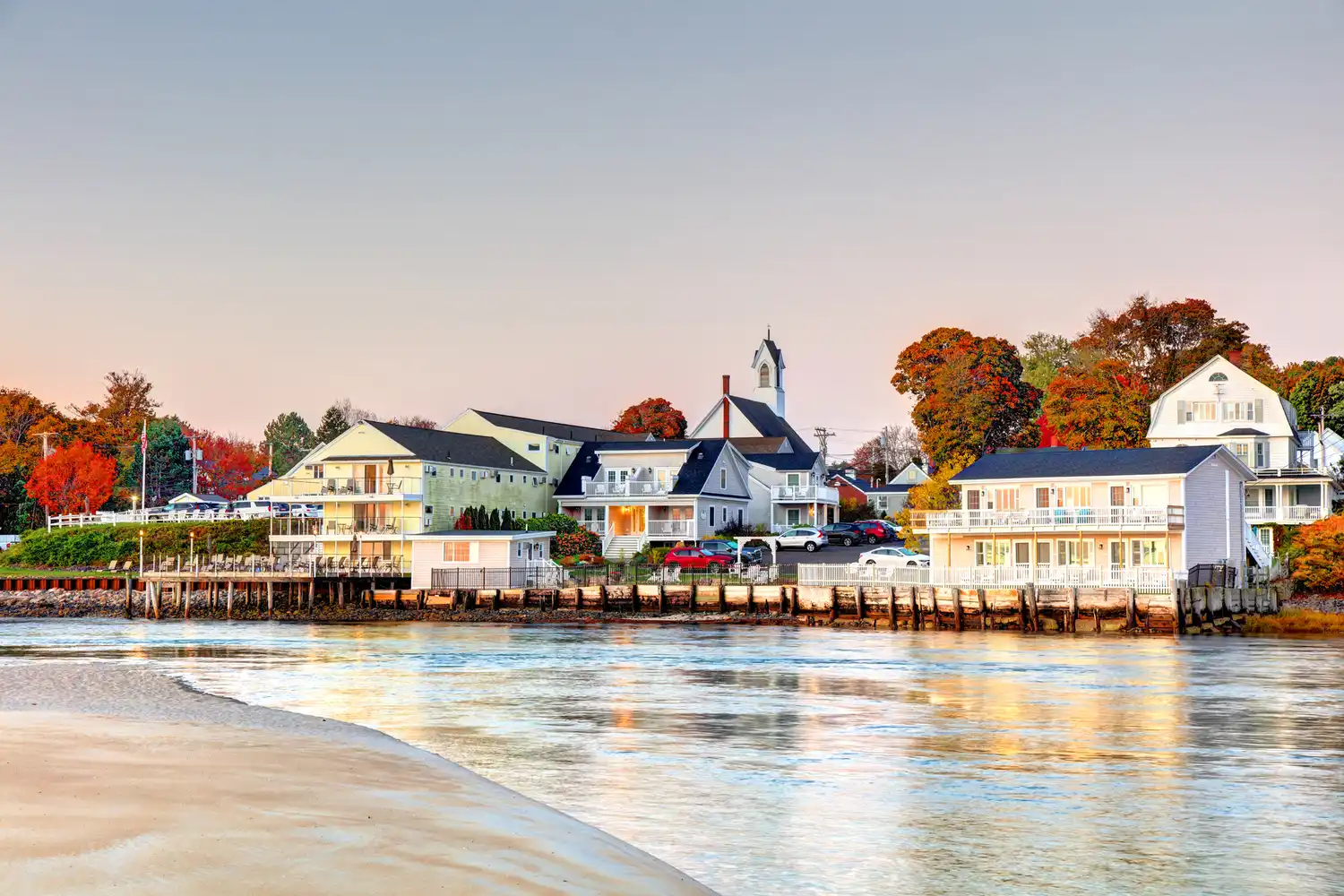 Scenic view of a church and houses by the water in Ogunquit, Maine, during the autumn season.