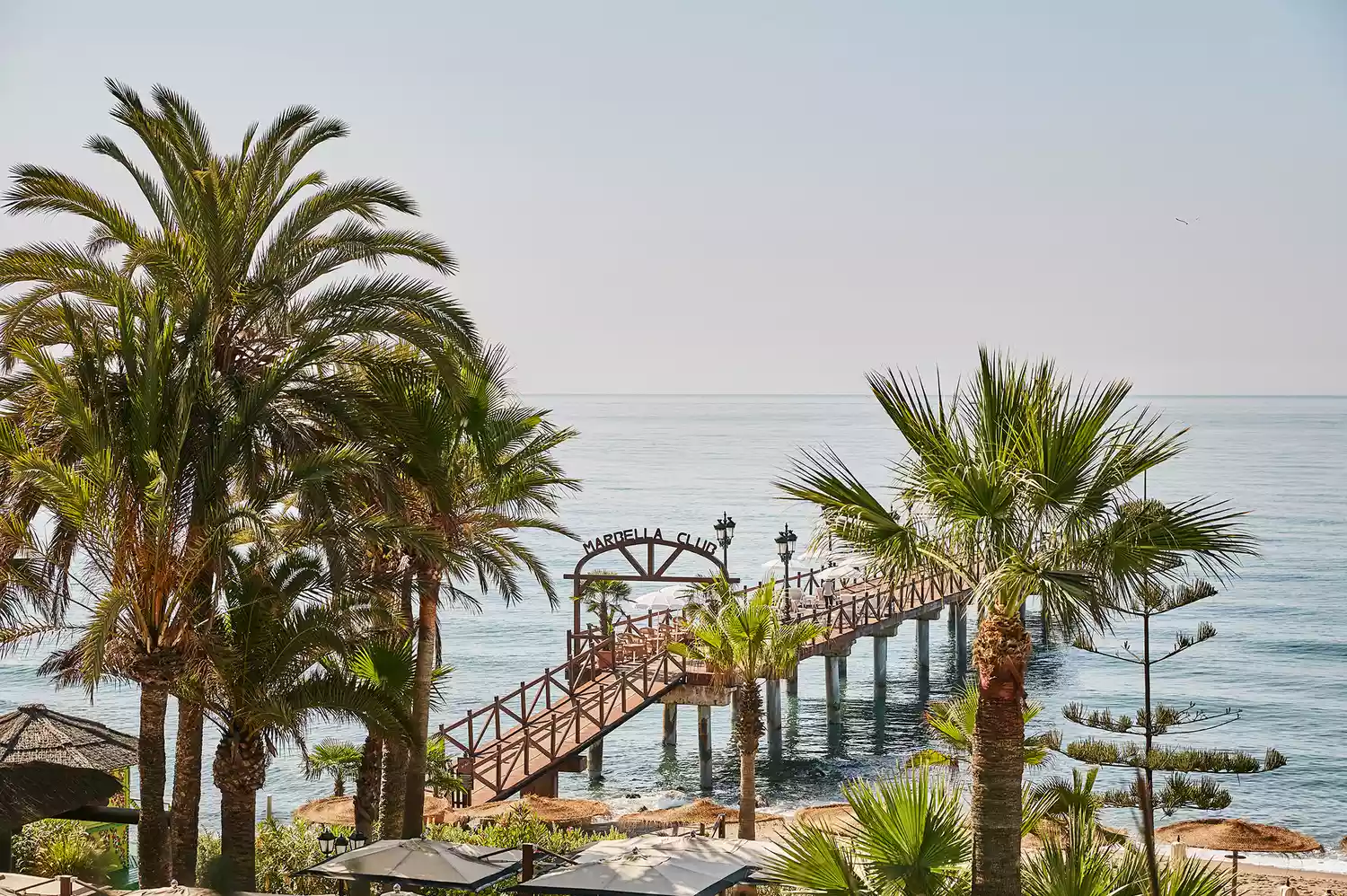 The al fresco beach club at Marbella Club with blue umbrellas and waterfront views.