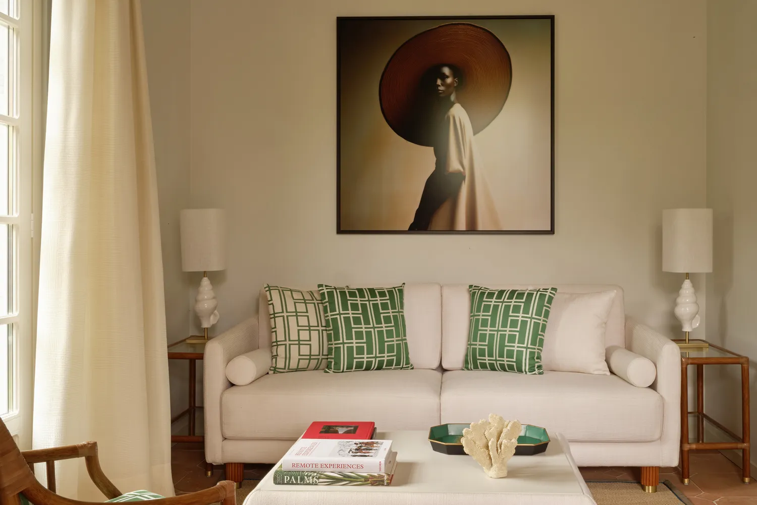 Brightly lit luxury garden suite with white sofas, green accents, and curated artwork.