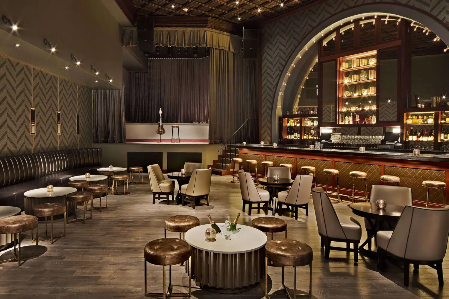 A glamorous and sophisticated bar and lounge area inside a luxury hotel with ambient lighting.