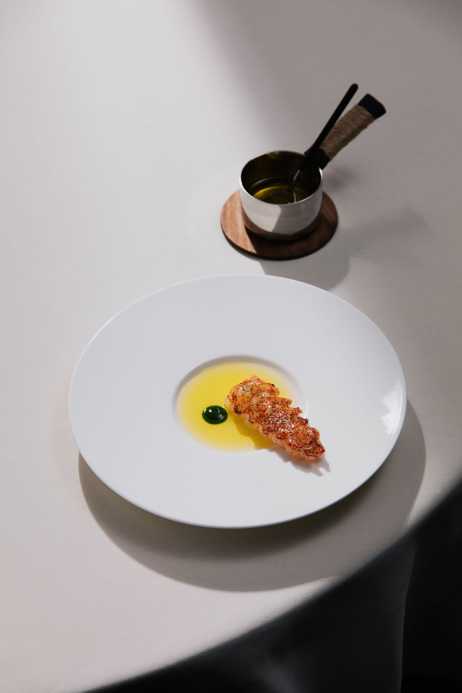 A sophisticated fine-dining plate featuring avant-garde presentation and culinary smoke.