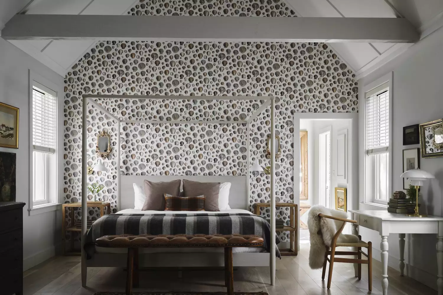 A bright, luxury bedroom interior at Hidden Pond featuring white Frette linens and forest-facing windows.