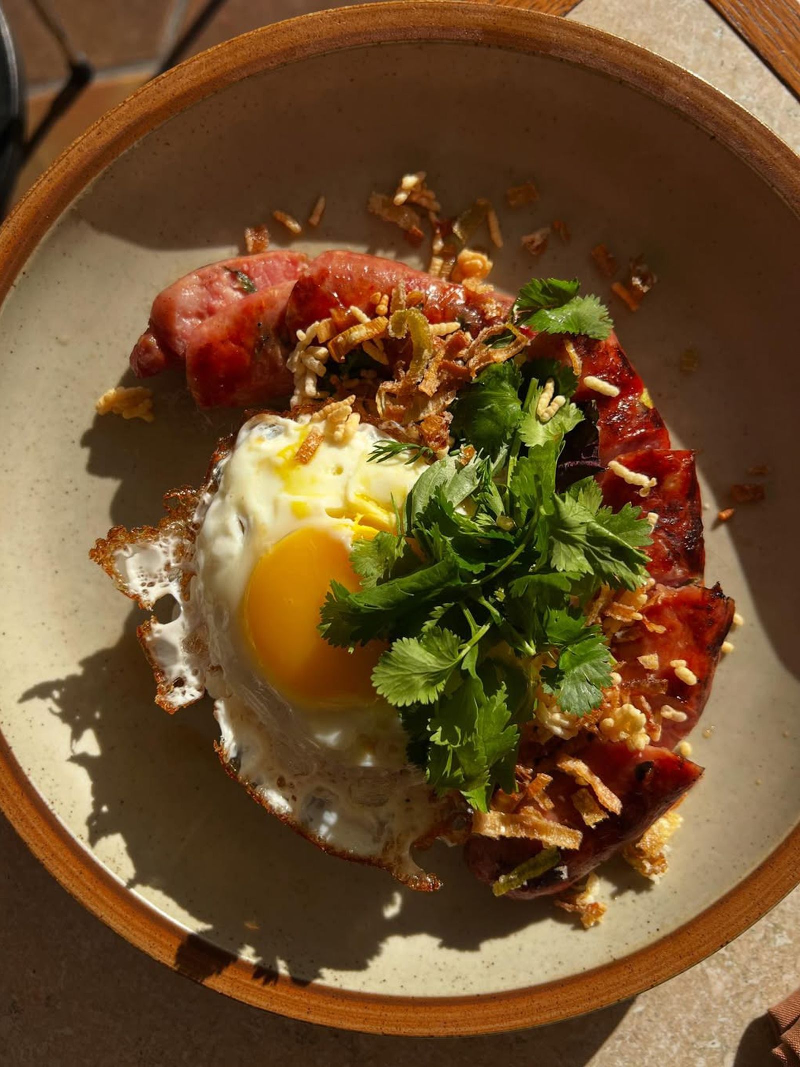 A close-up of a breakfast plate featuring a perfectly cooked fried egg and seasonal accompaniments.