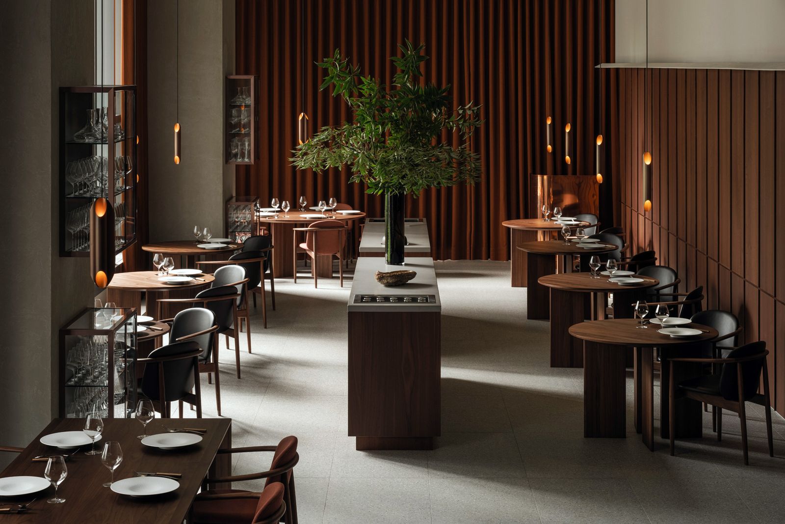 A warm restaurant interior with wooden furniture and a communal dining atmosphere.