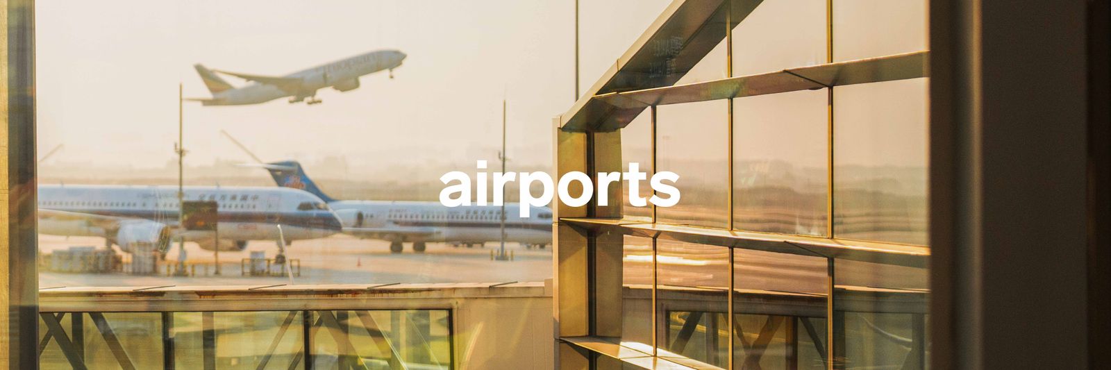 Modern aircraft on the tarmac near a contemporary airport terminal building.