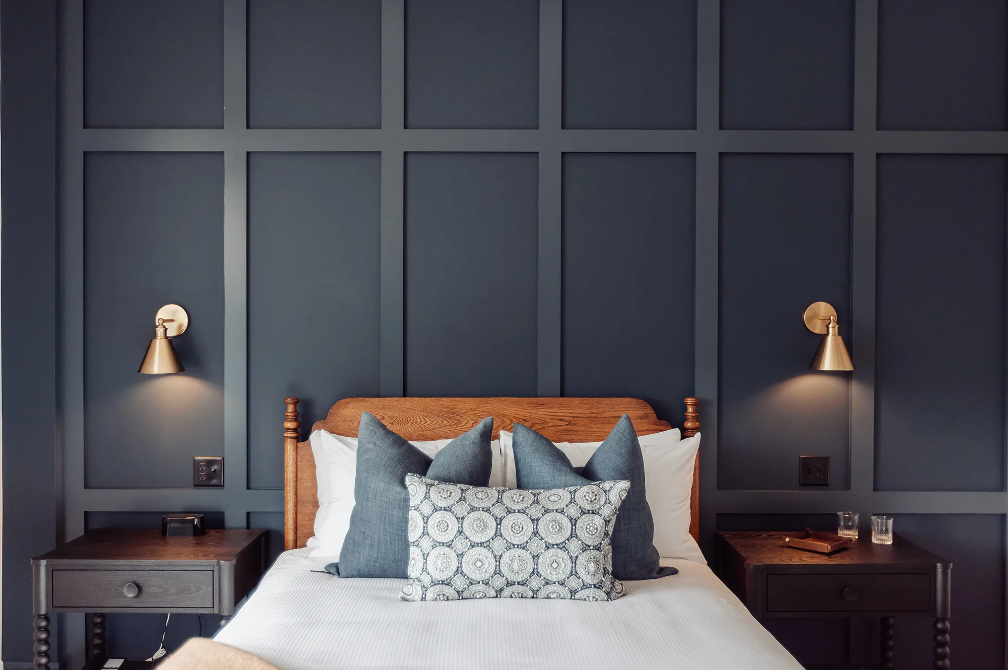 A detailed shot of a luxury hotel bedroom with a wooden headboard and designer linens.