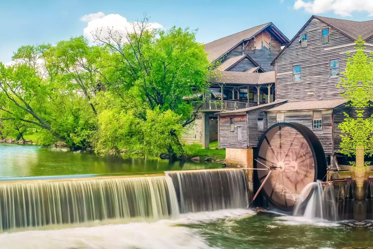 The Old Mill in Pigeon Forge with a small waterfall in the foreground.