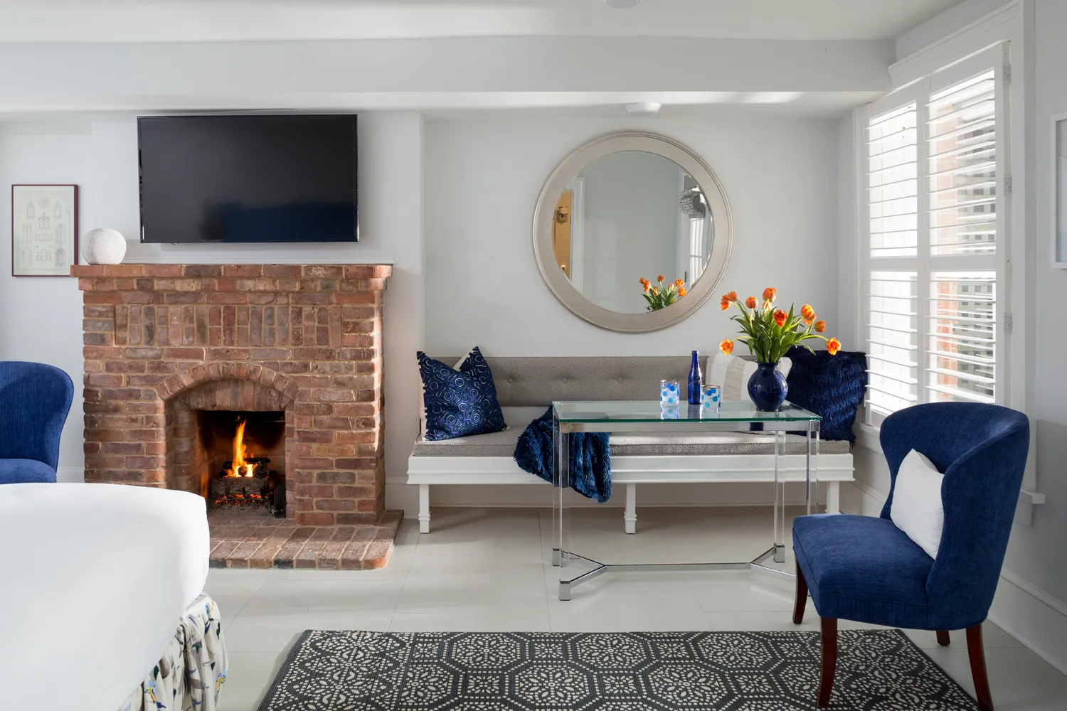 A luxurious guest room at Saratoga Arms featuring a brick fireplace and elegant furnishings.