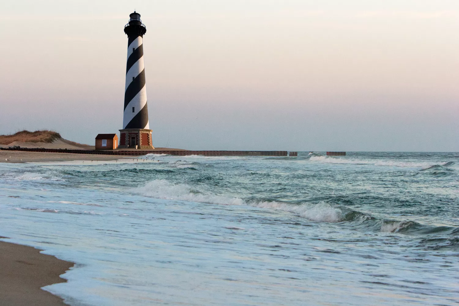 The black and white striped Cape Hatteras lighthouse against a blue sky.