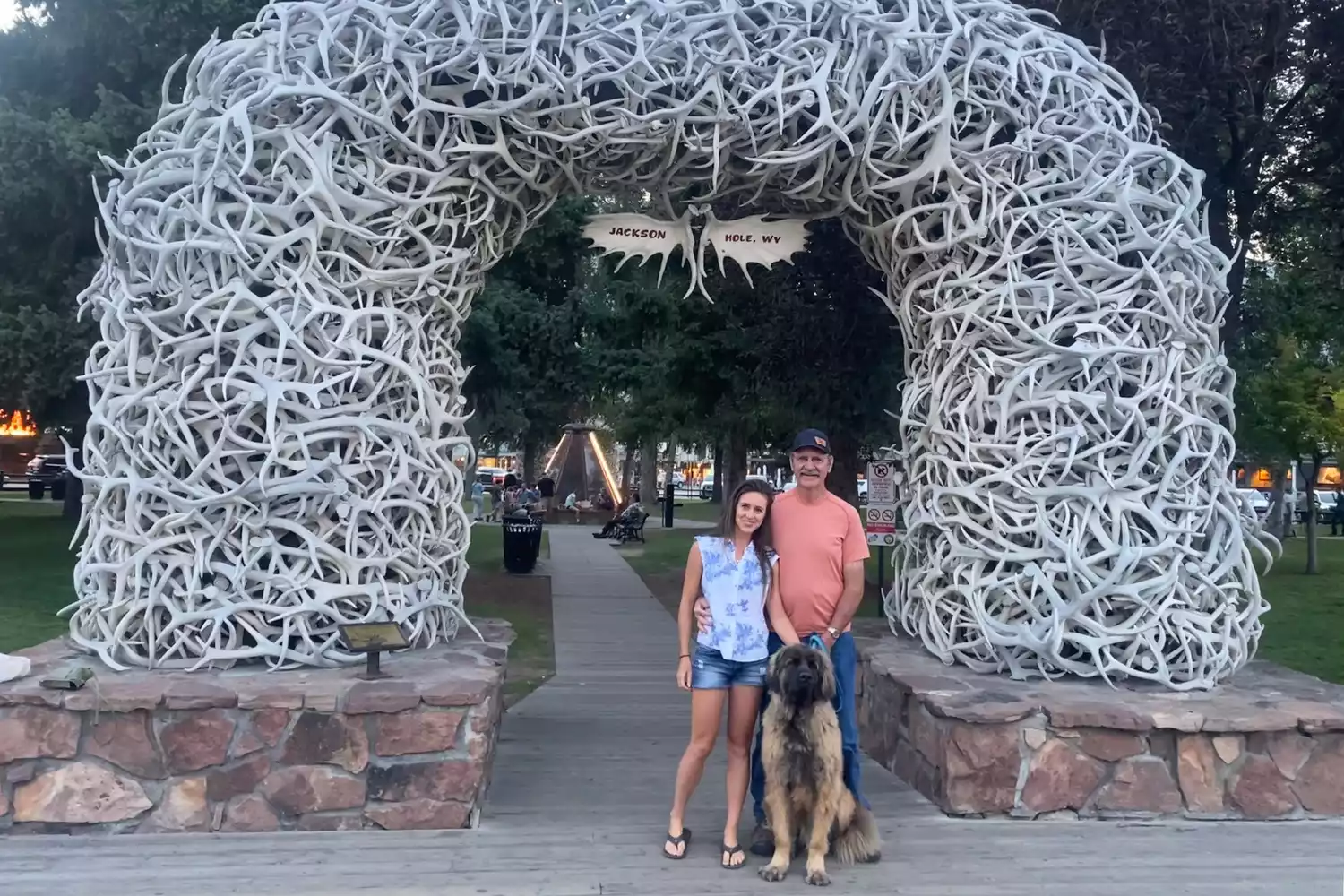 A father and daughter sharing a happy moment with a dog in an outdoor setting in Jackson Hole, Wyoming.