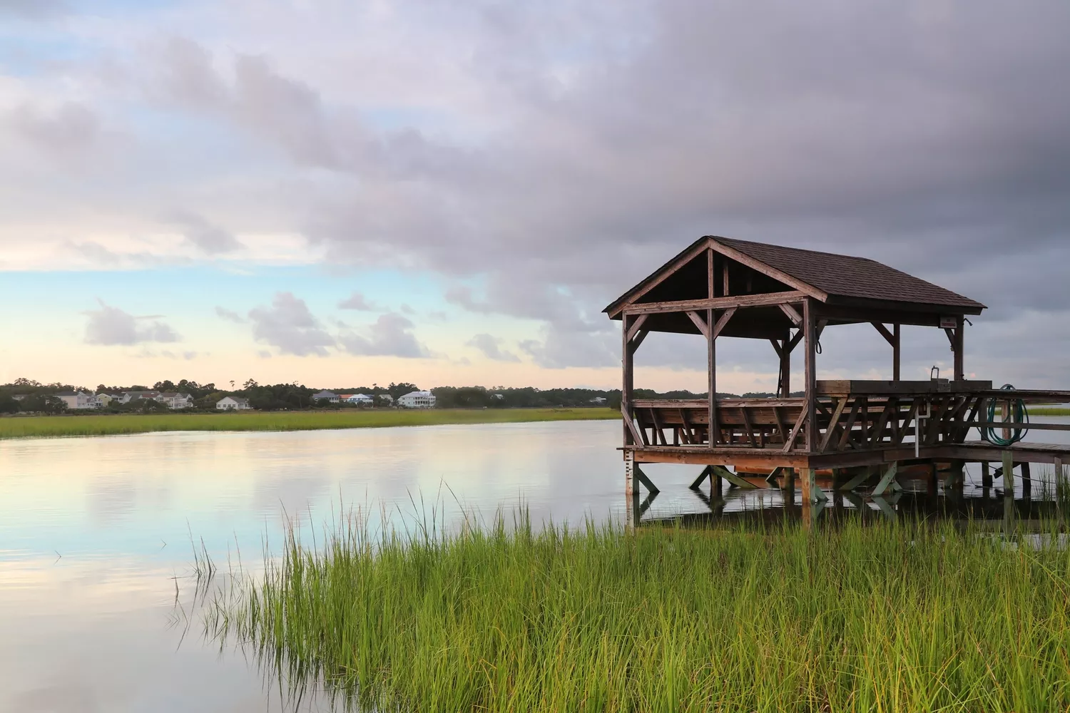 A wooden fishing dock and gazebo over calm bay waters at twilight near Pawleys Island.