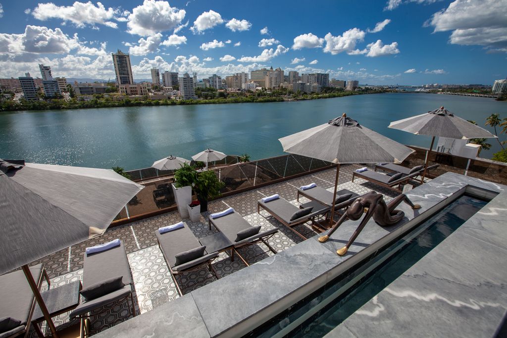 The green-covered exterior and modern lobby architecture of O:LV Fifty Five in San Juan.