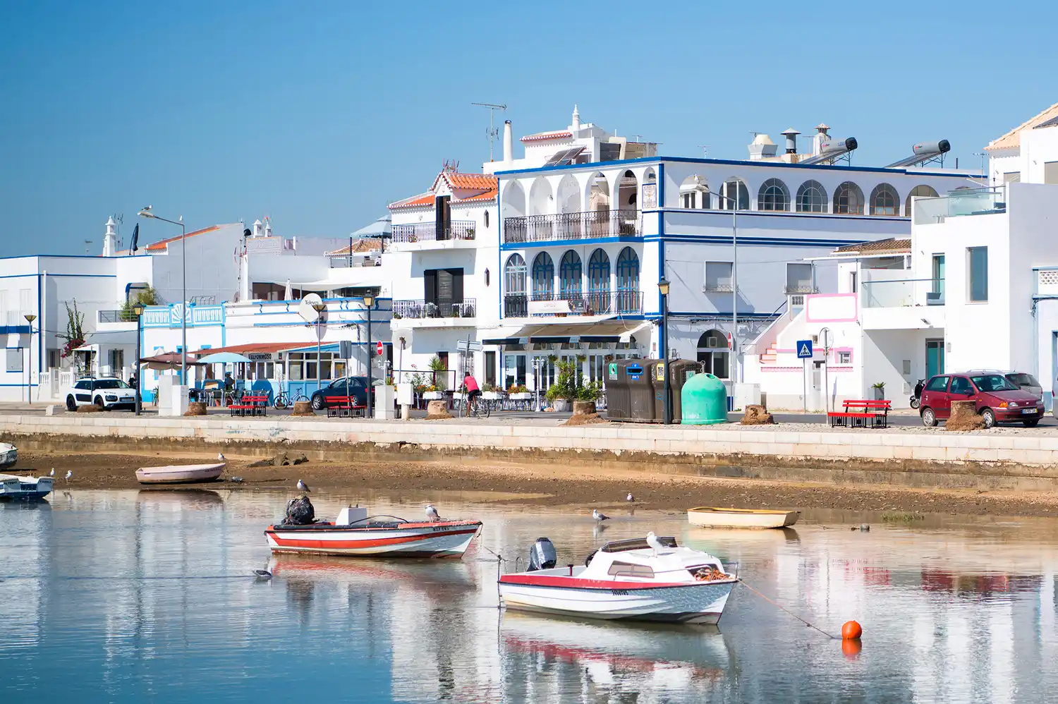 Blue and white fishing boats docked in the calm waters of Santa Luzia.