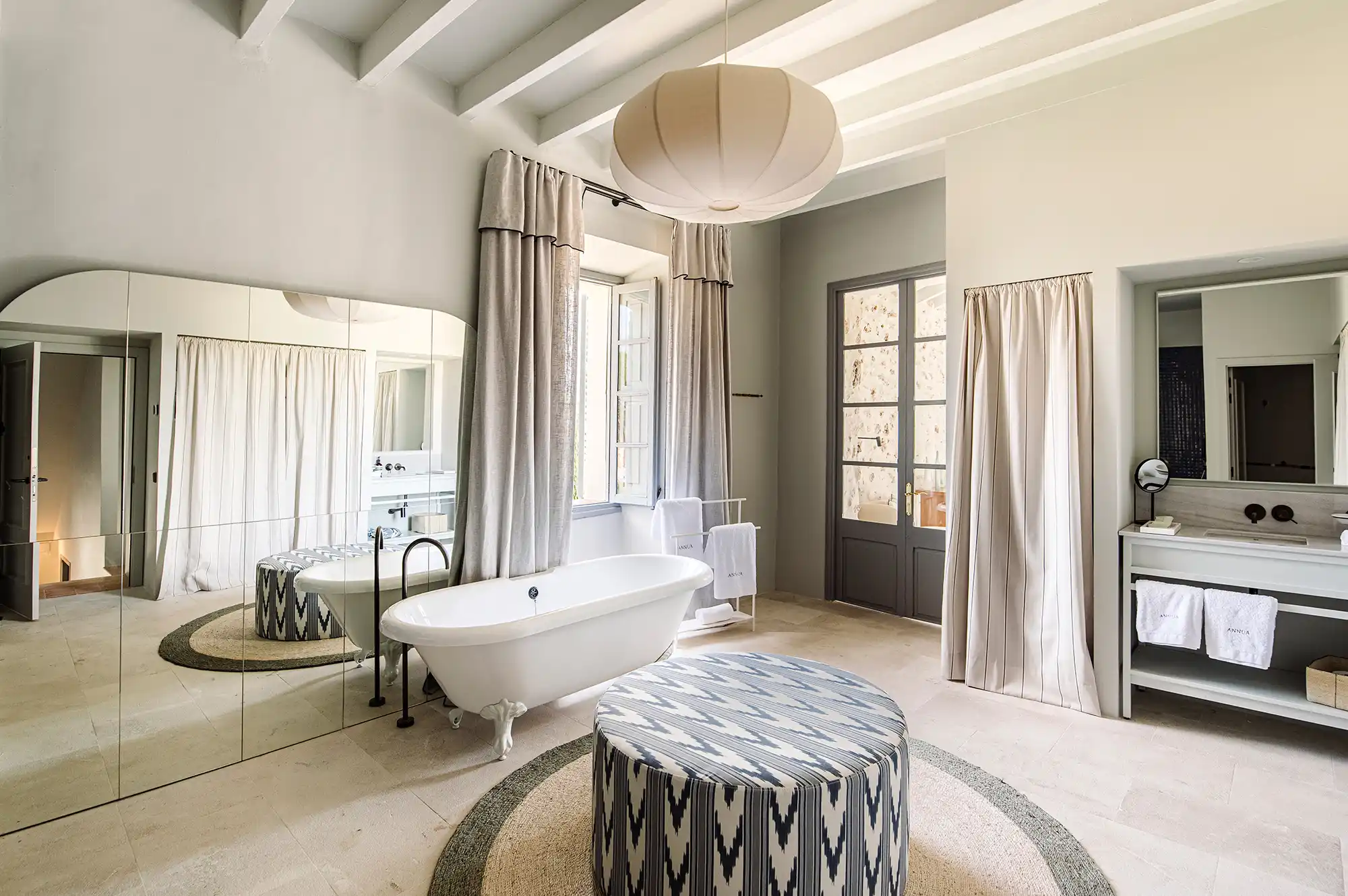 A luxury bathroom featuring a modern freestanding bathtub and a large vanity mirror.