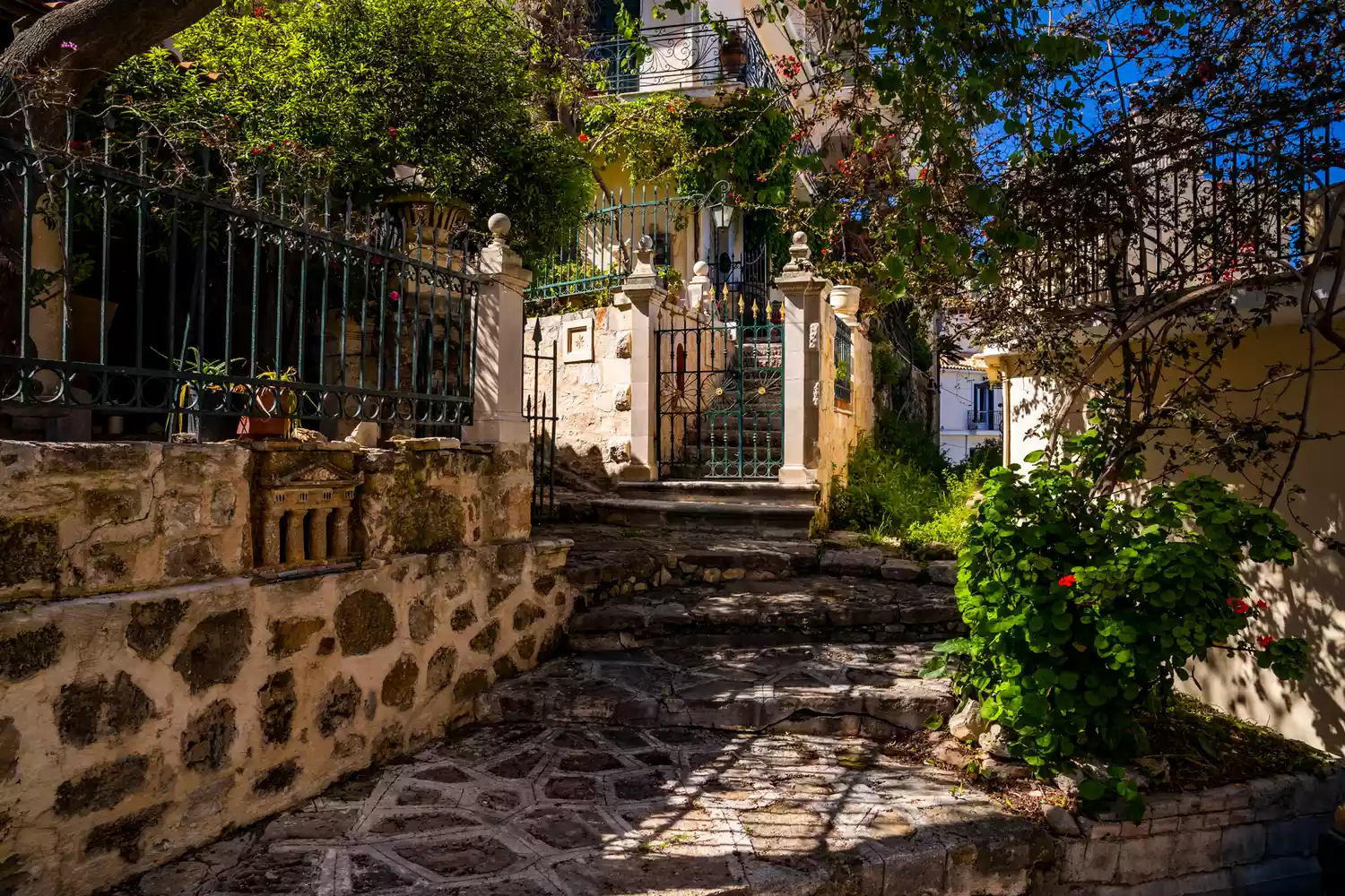 A narrow traditional street in Zakynthos town with stone walls and architectural details.