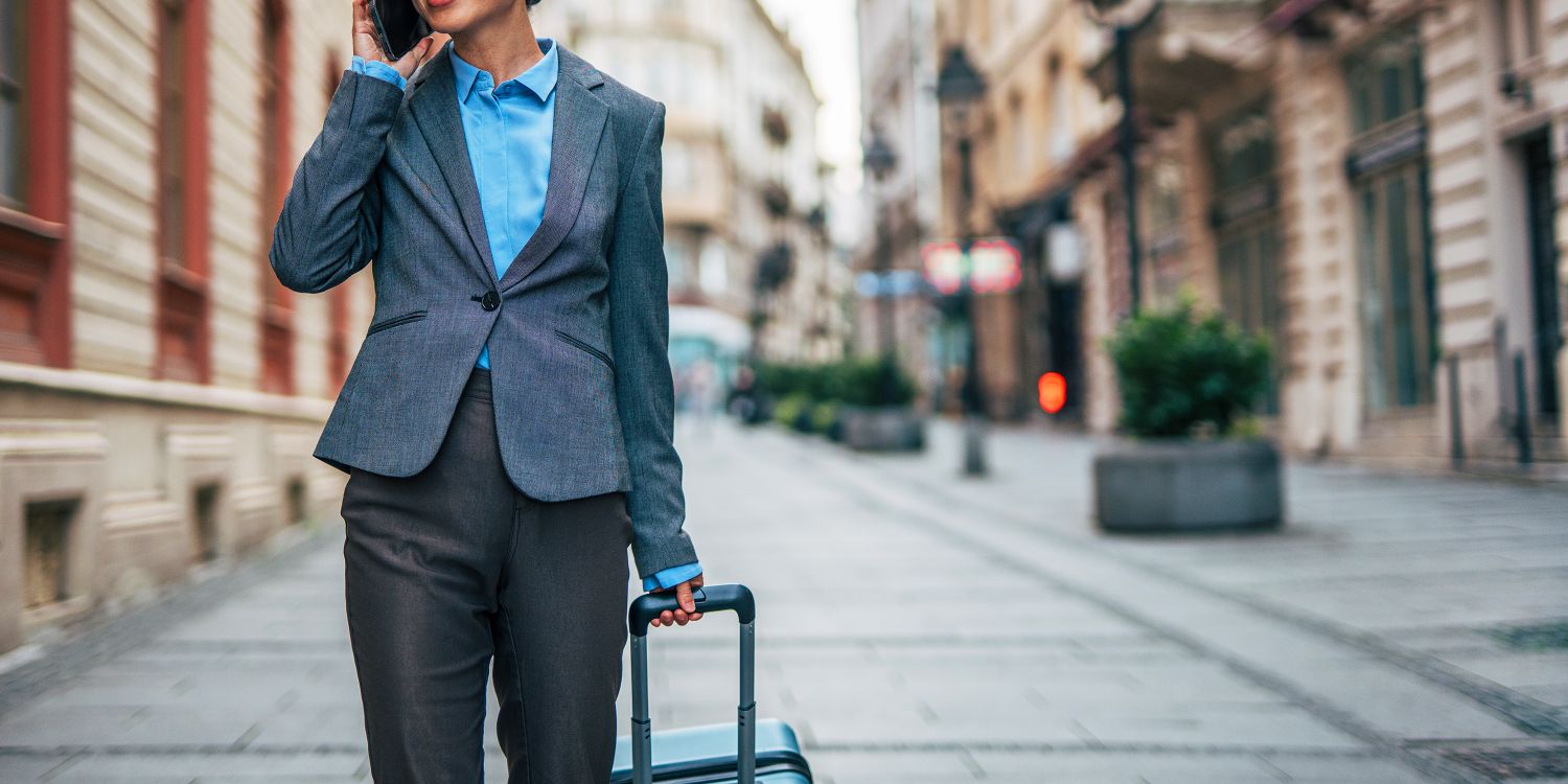 A collection of travel tech essentials including a smartphone with digital boarding pass and a portable VPN router.