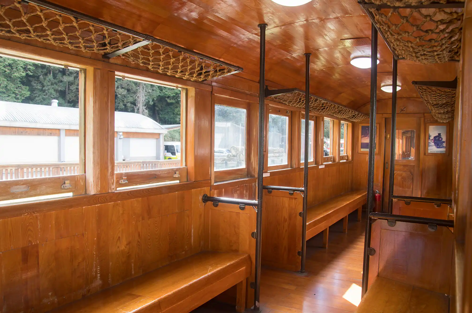 Interior view of a vintage Alishan train carriage with wooden paneling and blue seating.