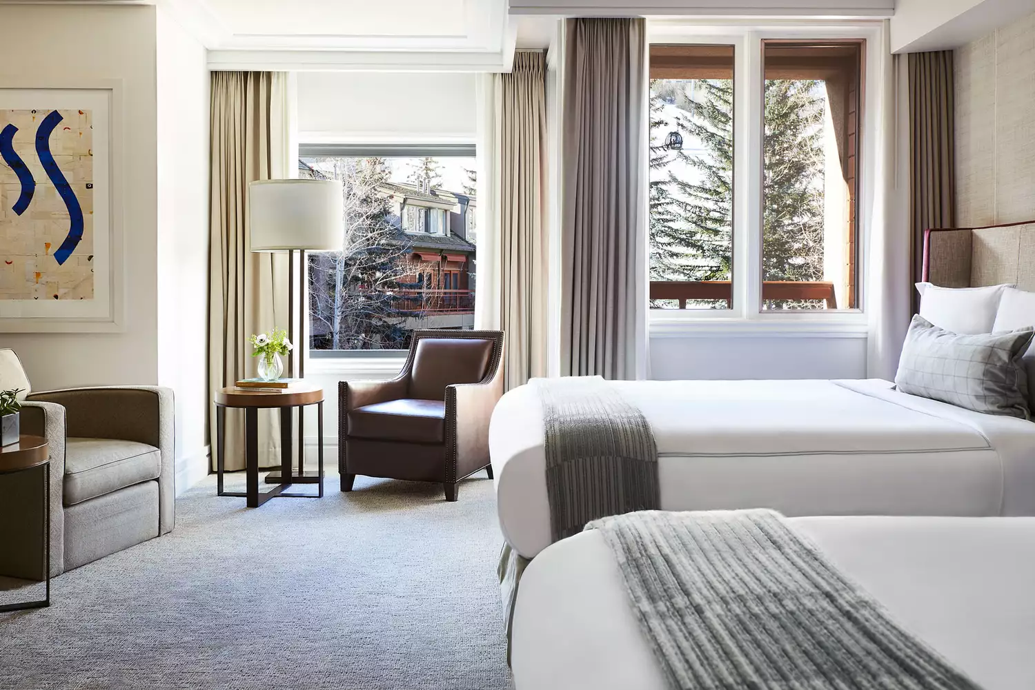 A luxury guestroom at The Little Nell with a view of the mountains from the window.