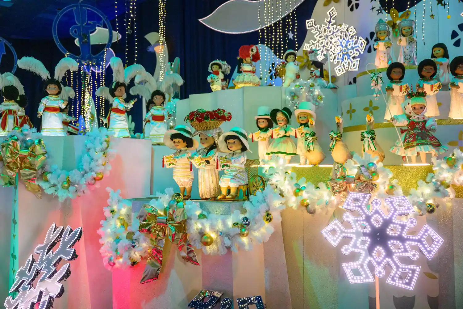Festive holiday-themed animatronic figures inside the It's a Small World ride at Disneyland.
