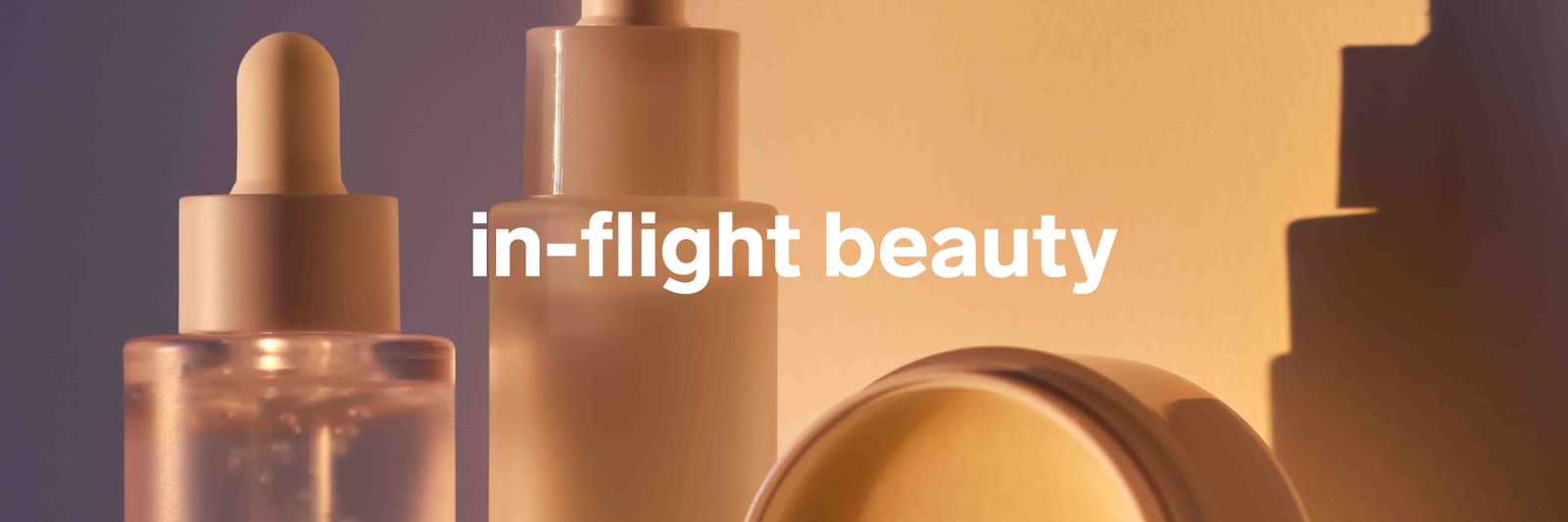 Close-up of luxury cosmetic bottles and skincare lotion on a clean surface.