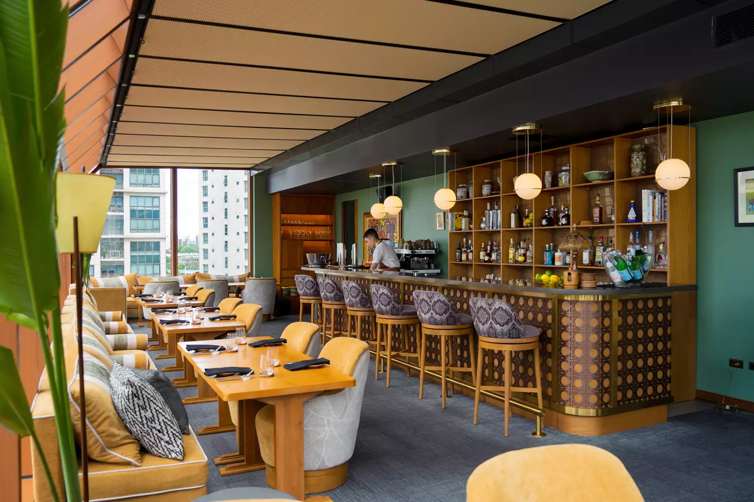 The contemporary bar and seating area of Ayà wine bar showing a wood-heavy industrial design.