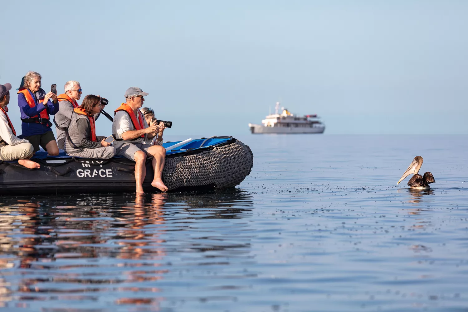 Travelers on a black Zodiac boat observing wildlife in the Galapagos Islands.
