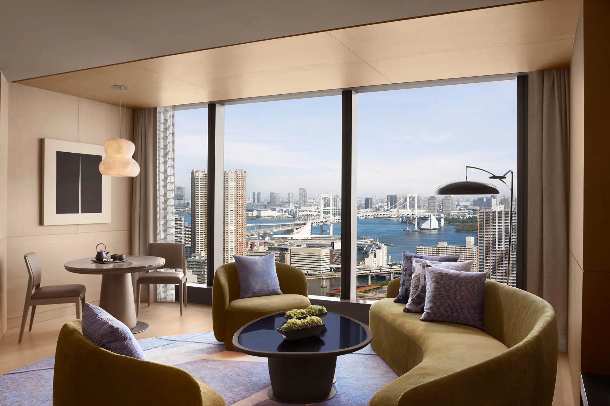 A luxury hotel suite with floor-to-ceiling windows overlooking Tokyo Bay.