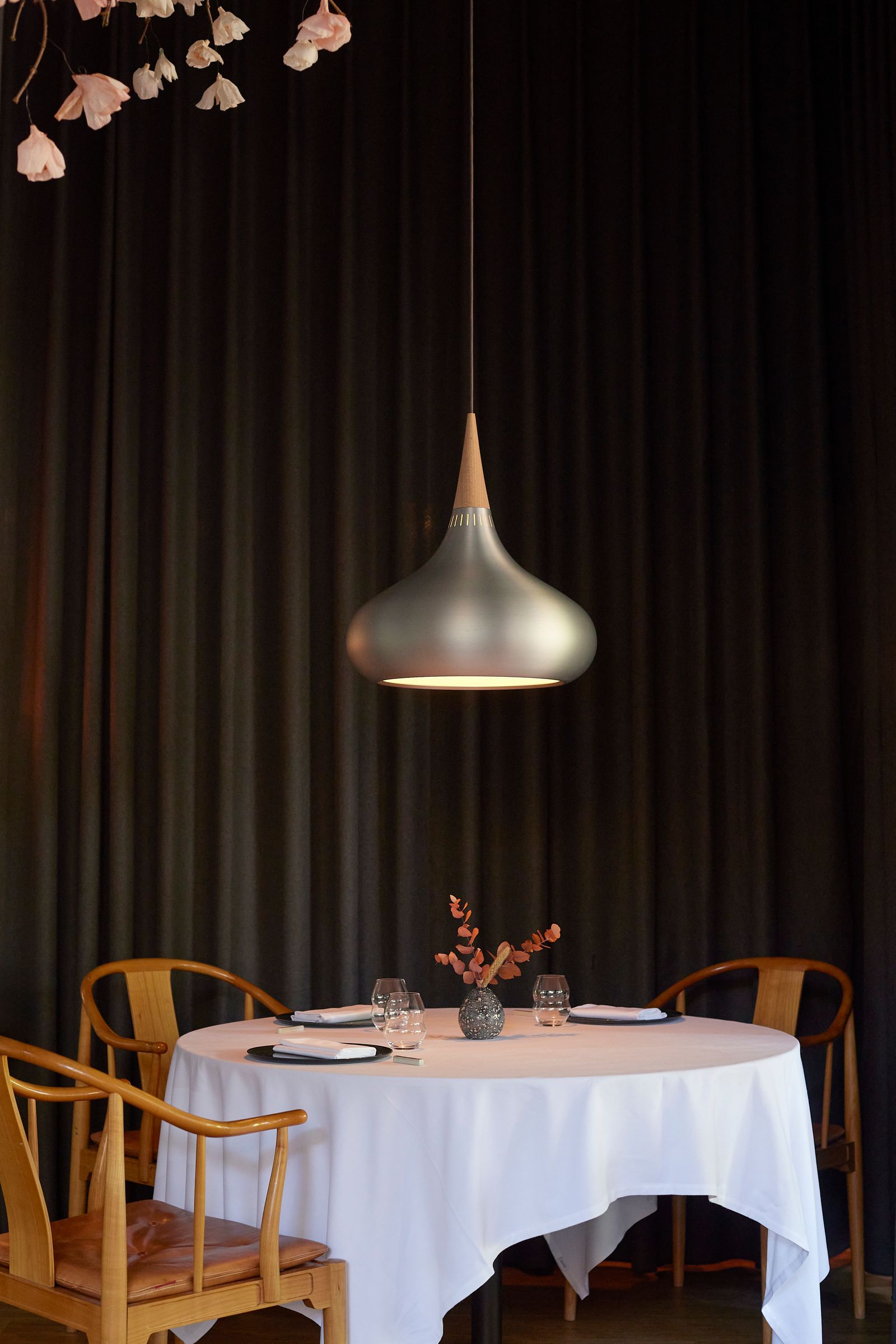 Elegant indoor dining room with classic furniture, warm lighting, and white tablecloths.
