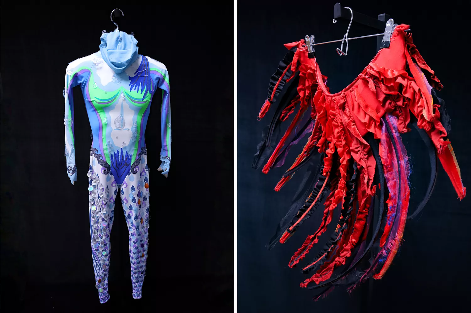 An assortment of colorful costume pieces and theatrical props displayed on museum pedestals.