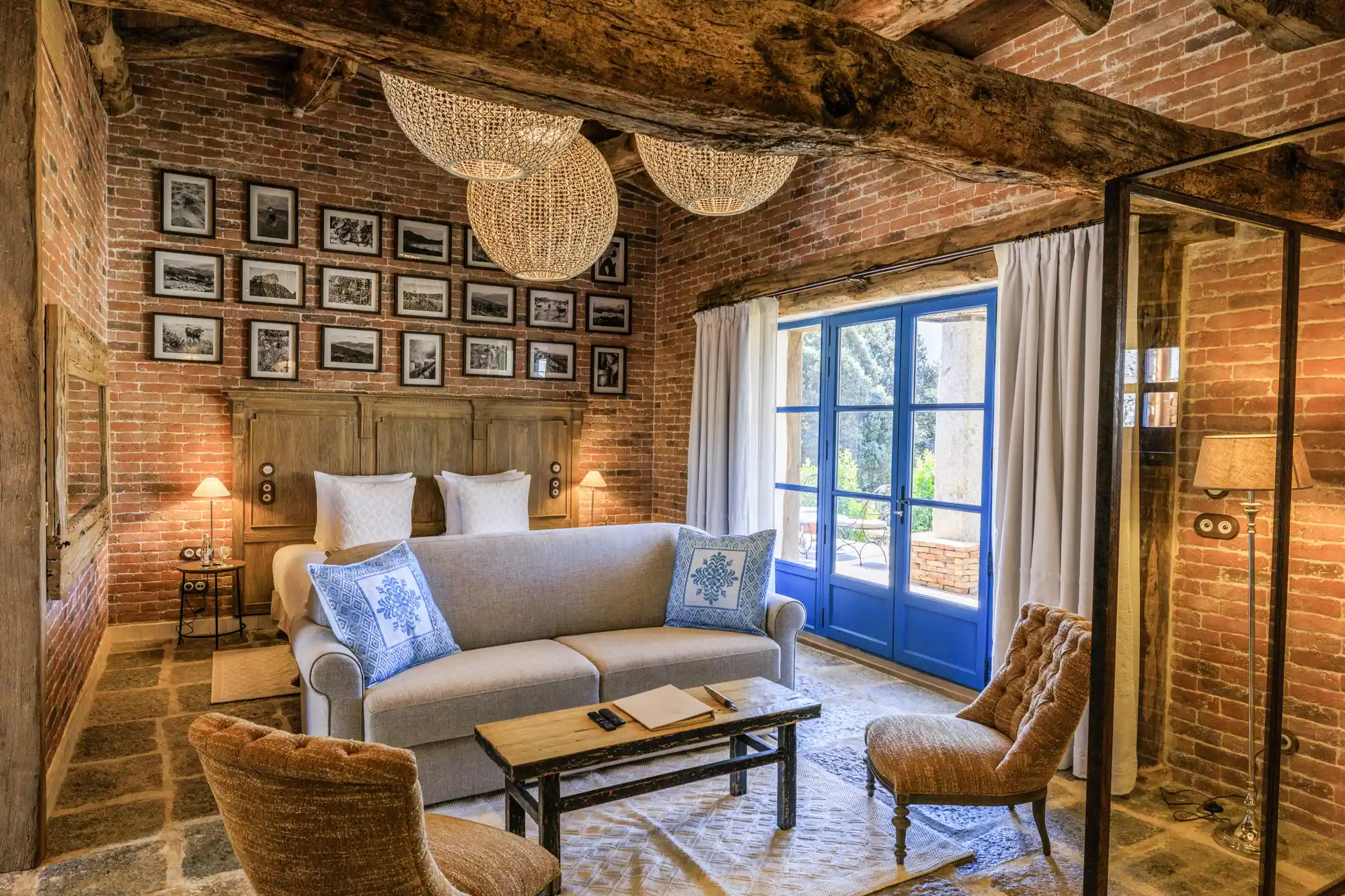 Cozy indoor seating area with rustic wooden beams and a large window looking out onto a garden.