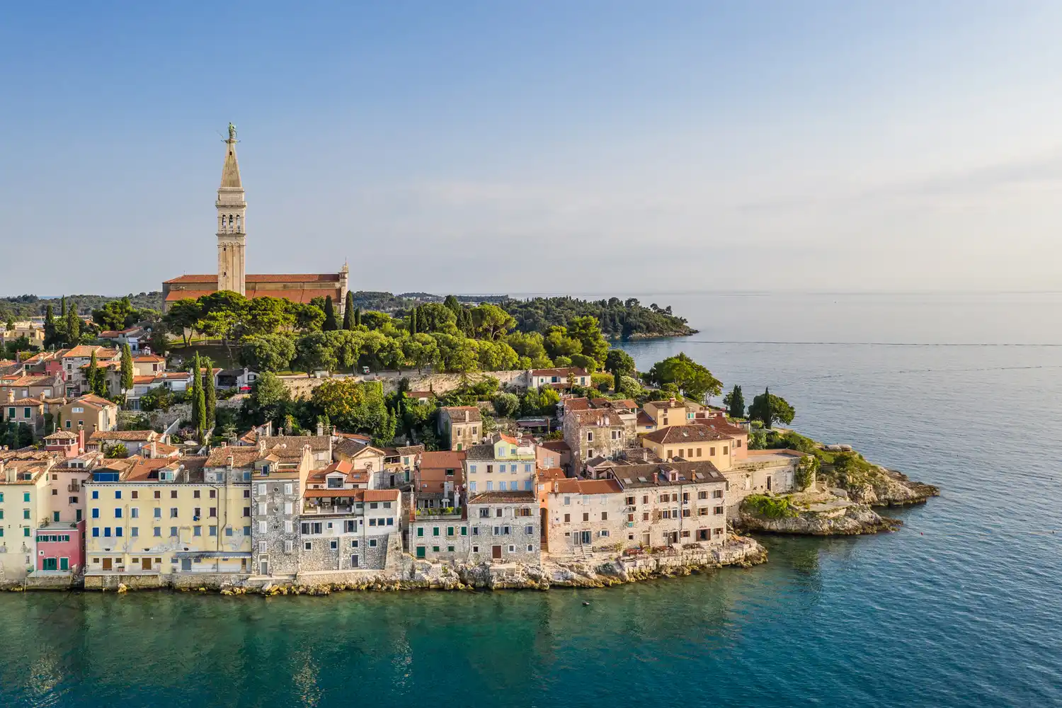 Aerial view of the Rovinj old town peninsula extending into the blue Adriatic Sea.